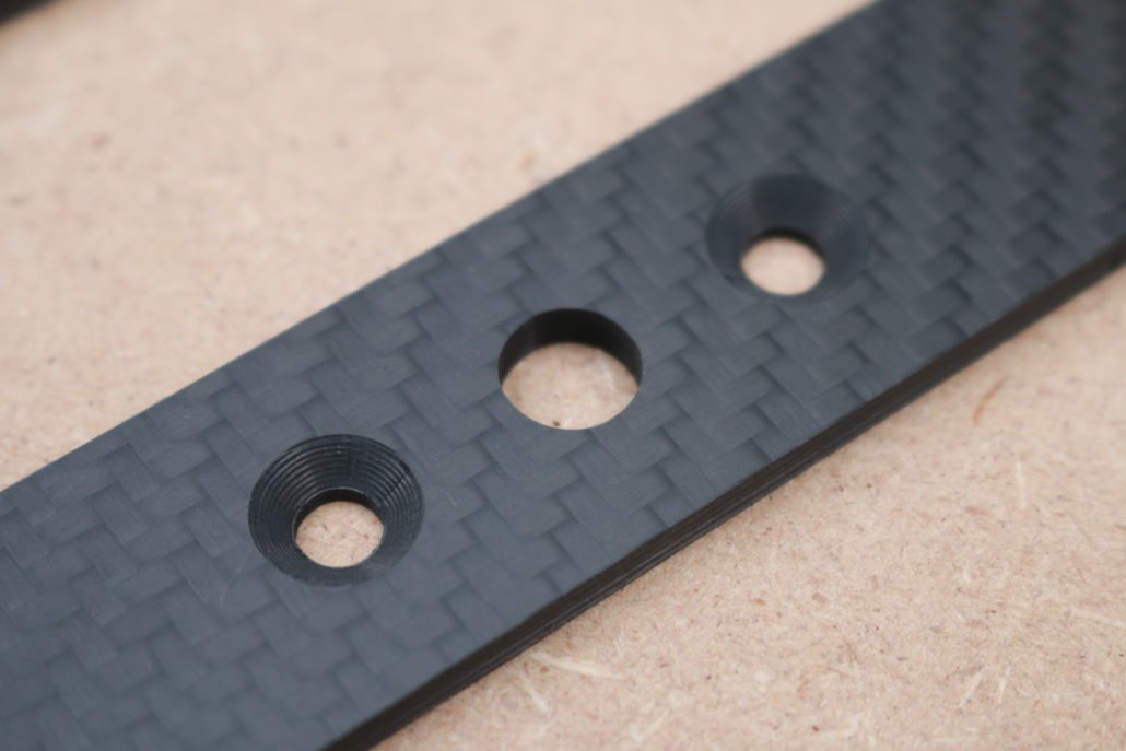 Drill holes with counterbores in carbon fibers